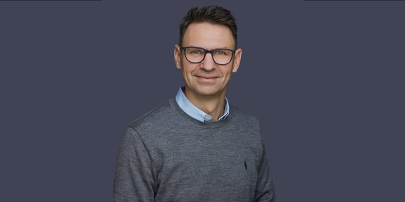 Portrait of CTO Torben Skov Hansen on a dark grey-blue background
