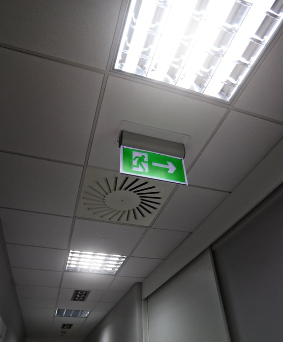 Loft med exit-skilt og to lamper med kraftigt hvidt lys