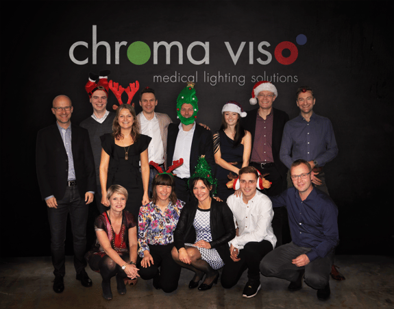 Chromaviso's employees pose with Christmas hats in front of Chromaviso's logo in a Christmas picture