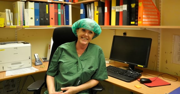 Anja Fönslund, teknisk ansvarlig sygeplejerske sidder og smiler ved sit skrivebord