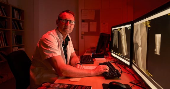 Ulrik Westrup, seniordyrlæge, sidder og observerer røntgenfotos i ergonomisk lys fra Chromaviso
