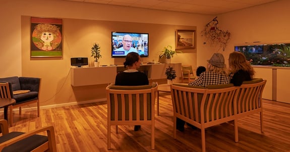 Vårdhemsboende tittar på TV i vardagsrummet på Vårdhem Rosenvang med dygnsrytmljus från Chromaviso