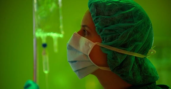 Surgeon looks at screen during operation while ergonomic light Chroma Zona lights up the room