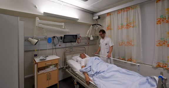 Läkare Anders West tar hand om en patient i sjukhusrummet på Glostrup Sjukhus där Chromavisos dygnsrytmljus är installerat