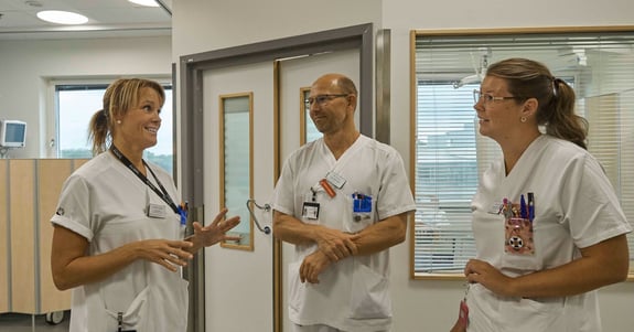 Sjukvårdspersonal samlas och samtalar på sjukhusets korridorer